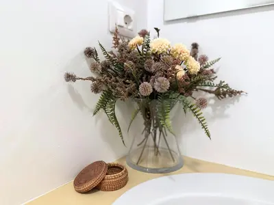 a vase of flowers on a counter next to a sink at Casa Lovera in Vaticano in Rome