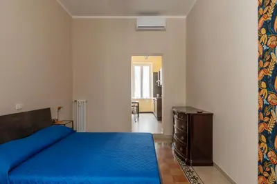 a bedroom with a blue bed and a dresser at GuestHost - Functional Apartment Piazza Re di Roma in Rome