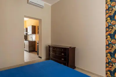 a bedroom with a bed and a dresser and a kitchen at GuestHost - Functional Apartment Piazza Re di Roma in Rome