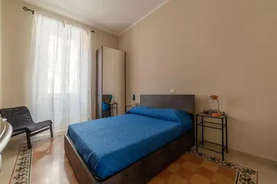 a bedroom with a blue bed and a chair at GuestHost - Functional Apartment Piazza Re di Roma in Rome