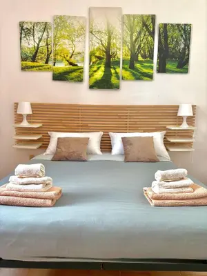 a bedroom with a bed with four paintings on the wall at Appia Suite in Rome