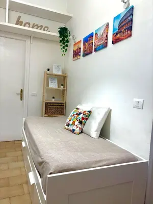 a bed in a room with pictures on the wall at Appia Suite in Rome