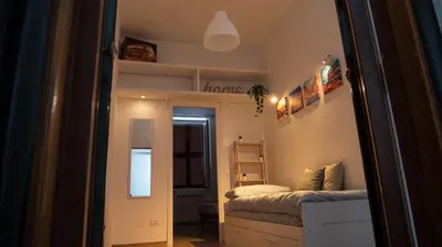 a small bedroom with a bed and a mirror at Appia Suite in Rome