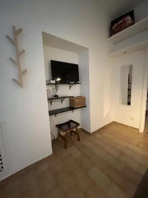 a living room with a tv on a white wall at Appia Suite in Rome