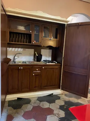 a kitchen with wooden cabinets and a sink at Termini GHome in Rome