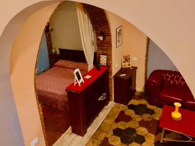 a bedroom with a red bed and a red chair at Termini GHome in Rome