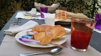 a table with a plate of pastries and a drink at Domus Lunae in Rome