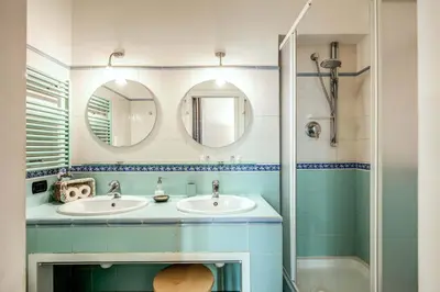 a bathroom with two sinks and two mirrors at Domus Lunae in Rome