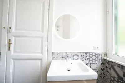 a white bathroom with a sink and a mirror at Lovely and new apartment near Termini Station in Rome