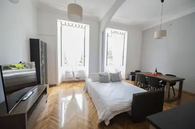 a white living room with a bed and a table at Lovely and new apartment near Termini Station in Rome
