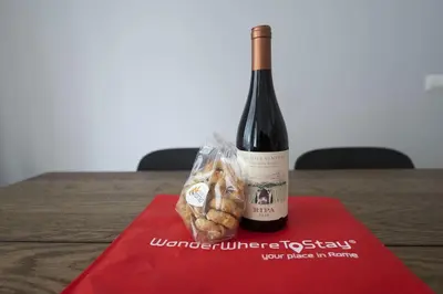 a bottle of wine and a bag of bread on a table at Lovely and new apartment near Termini Station in Rome