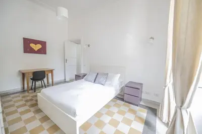 a white bedroom with a bed and a desk at Lovely and new apartment near Termini Station in Rome