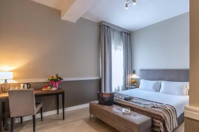 a hotel room with a bed and a desk and a chair at Fragrance Hotel St. Peter in Rome