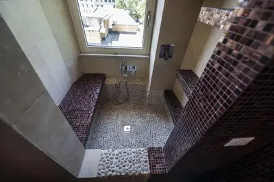 a bathroom with a walk in shower with brown tiles at Testaccio Luminous and Large Apartment in Rome