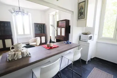 a kitchen with a counter with chairs and a table at Testaccio Luminous and Large Apartment in Rome