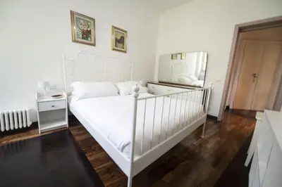 a bedroom with a white bed and a mirror at Testaccio Luminous and Large Apartment in Rome