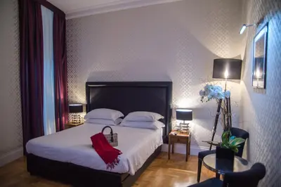 a bedroom with a white bed with a red blanket at Minerva Relais in Rome
