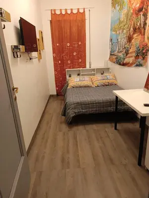a small room with a bed and a table at Romamor 2 in Rome