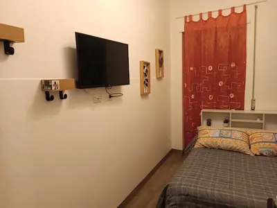 a bedroom with a bed and a flat screen tv on the wall at Romamor 2 in Rome