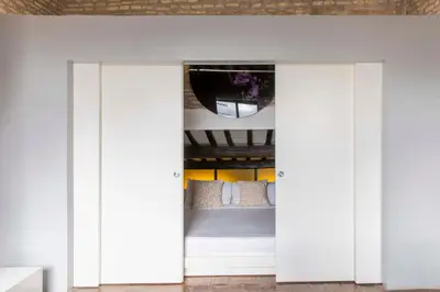 a bedroom with white doors leading to a bed at Monti apartment BDB in Rome