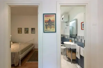 a bathroom with a sink and a bed and a mirror at Casa Bouganville - St. Peter Romantic Apartment in Rome