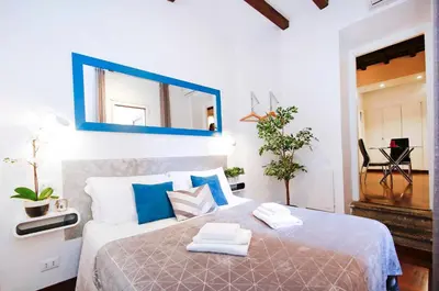a bedroom with a large bed with a blue mirror at Collection Spanish Steps Apartments in Rome