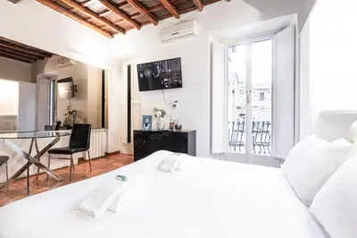 a white bedroom with a white bed and a desk at Collection Spanish Steps Apartments in Rome