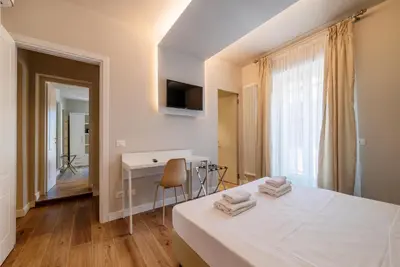 a bedroom with a bed and a desk and a window at Luxury Corso Suite - DesignD Stays in Rome