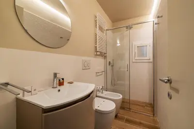a bathroom with a sink and a toilet and a mirror at Luxury Corso Suite - DesignD Stays in Rome