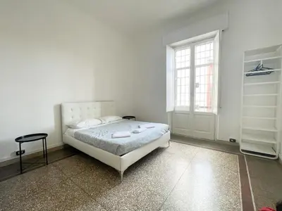 a white bedroom with a bed and a window at Angelico Boutique Apartment in Rome