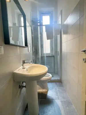 a bathroom with a sink and a toilet and a mirror at Angelico Boutique Apartment in Rome