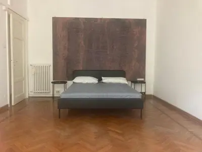 a bed in a room with a painting on the wall at Angelico Boutique Apartment in Rome
