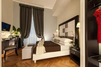 a bedroom with a bed and a desk and a chair at DVE Suite Rome in Rome