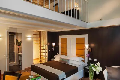 a bedroom with a large bed and a staircase at DVE Suite Rome in Rome