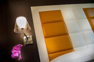 a room with a lamp and flowers on a wall at DVE Suite Rome in Rome