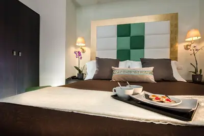 a bed with a tray with a plate of food on it at DVE Suite Rome in Rome
