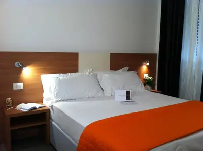 a hotel room with a bed with a book on it at Holidays S.Lorenzo Guest House New in Rome