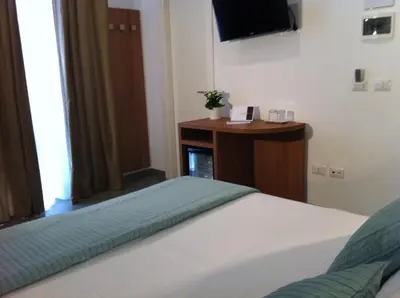 a bedroom with a bed and a tv and a table at Holidays S.Lorenzo Guest House New in Rome