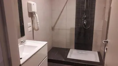 a small bathroom with a sink and a shower at Holidays S.Lorenzo Guest House New in Rome