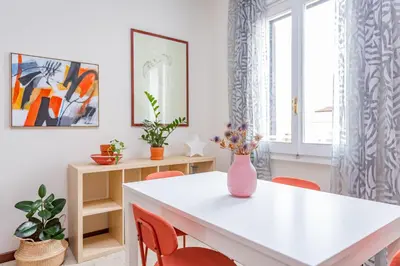 a dining room with a white table and orange chairs at Casa Stella in Rome
