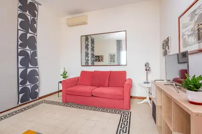a red couch in a living room with a mirror at Casa Stella in Rome