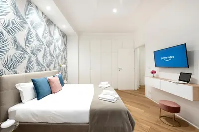 a bedroom with a bed and a tv on a wall at White flat Gallia in Rome