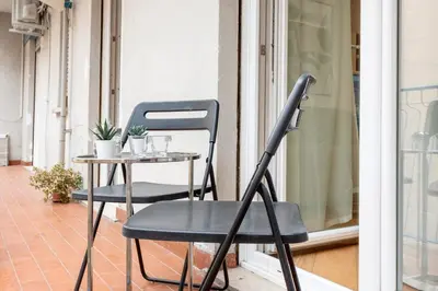 a chair and a table on a balcony at White flat Gallia in Rome