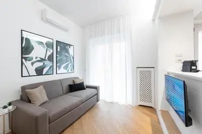 a living room with a couch and a flat screen tv at White flat Gallia in Rome