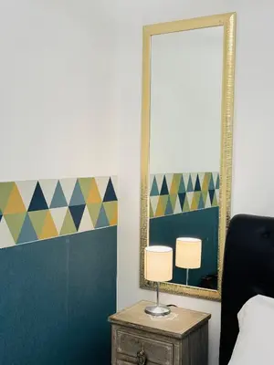 a bedroom with a mirror and a lamp on a table at Bencò House in Rome