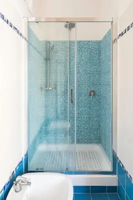 a blue tiled bathroom with a shower and a sink at Casa Angelina con 3 camere da letto in Rome
