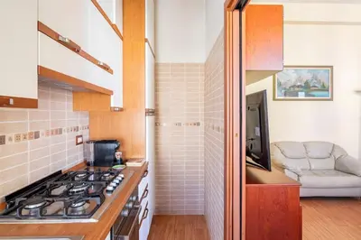 a kitchen with a stove and a couch in a room at Casa Angelina con 3 camere da letto in Rome