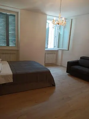 a bedroom with a bed and a couch and a chandelier at Harmony in Rome in Rome