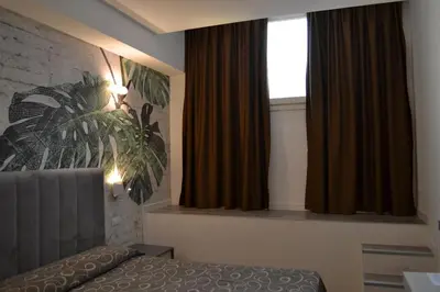 a bedroom with a bed and a window with curtains at Hotel Galileo in Rome