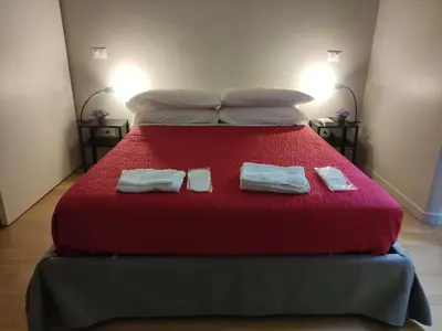 a large red bed with two towels on it at 150 m dal Colosseo - Appartamento Minerva in Rome